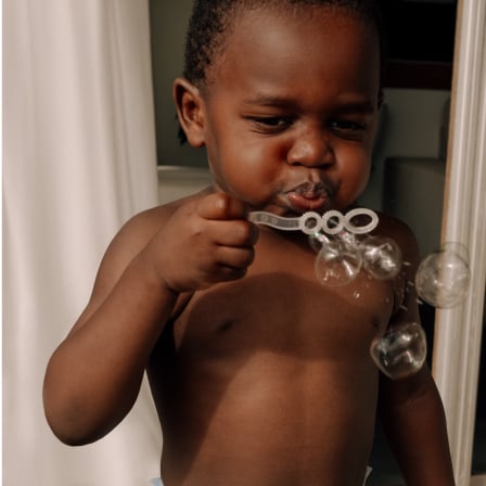 Baby boy blowing bubbles, highlighting Huggies® Simply Clean® Wipes Huggies® Skin Essentials™ wipes 30% thicker than Pampers® Aqua Pure™ Huggies® Skin Essentials™ wipes, free of harsh ingredients