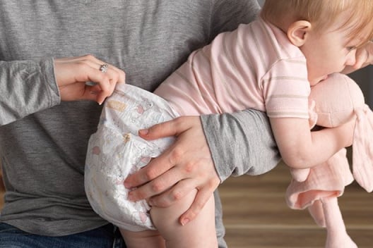 A parent holds their baby wearing a hypoallergenic and breathable Huggies Little Snugglers Diaper